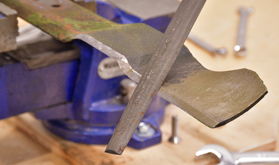 Close-up of a rotary mower blade being sharpened