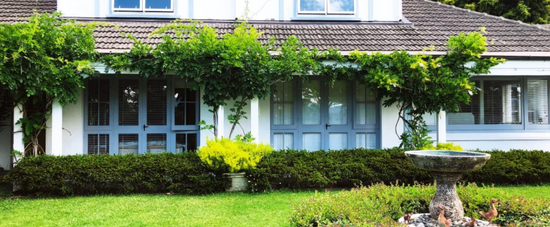 Photograph of a home with a beautiful lawn and trees
