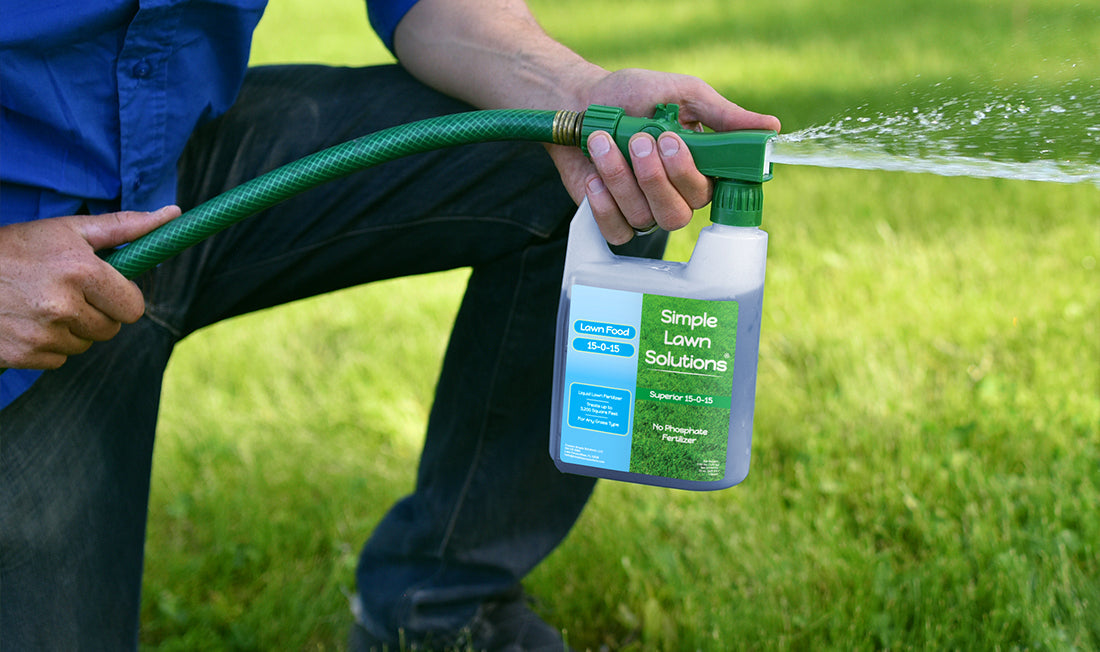 Man applying a liquid fertilizer with hose-end sprayer to lawn