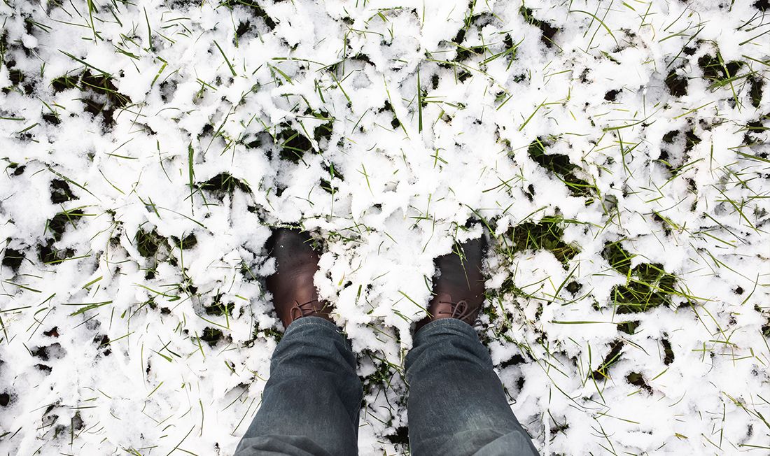 Person standing on a lawn covered in icy snow