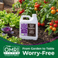 A white plastic jug of Simple Grow Solutions Site Pume pH 5.5 Syrup Acid fertilizer placed in a garden bed with tomato plants and leafy greens.